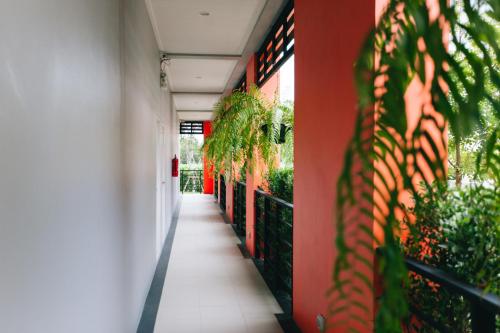 a hallway of a building with red walls and plants at Smart Hotel in Lam Luk Ka