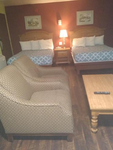 a hotel room with two beds and a chair at Econo Inn in Anchorage