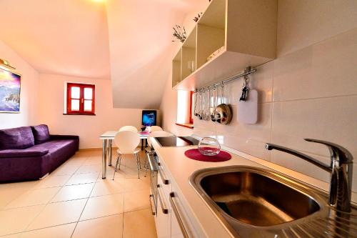 a kitchen with a sink and a living room at Sunny Bobica Apartments in Vodice