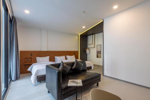 a hotel room with a bed and a couch at Reno hotel in Bangkok