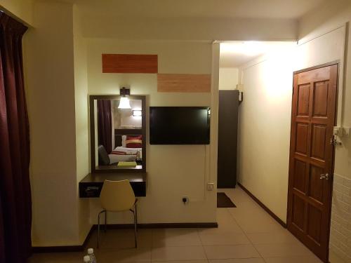 a room with a mirror and a chair and a bed at City Inn in Kuching