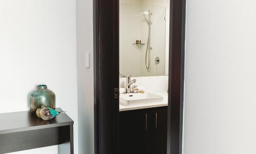 a bathroom with a sink and a shower at Coniston Hotel Wollongong in Wollongong
