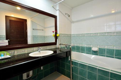 ein Badezimmer mit einem Waschbecken, einem Spiegel und einer Badewanne in der Unterkunft Samui First House Hotel in Chaweng