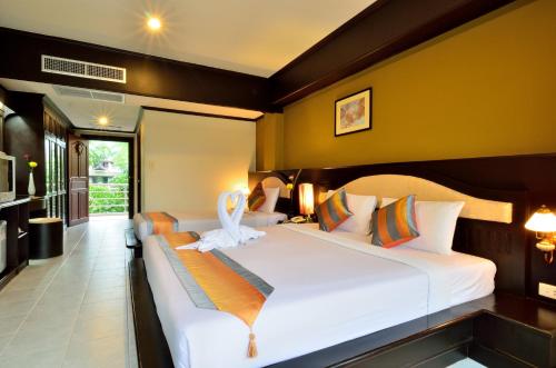 a bedroom with two beds with white sheets at Samui First House Hotel in Chaweng