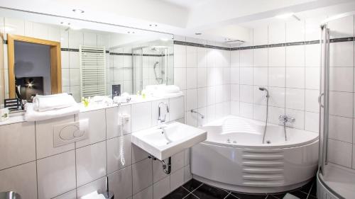 a white bathroom with a sink and a mirror at STEINHAUS 1718 in Büdingen