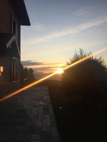 a sunset with the sun setting behind a building at Residence La Canonica in Costa Valle Imagna