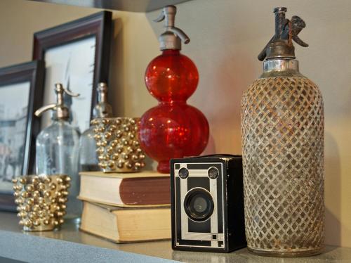 a bottle and a camera on a table with books at Georgetown Inn Seattle in Seattle
