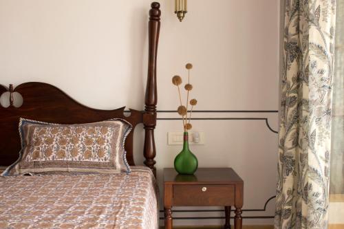 a bedroom with a bed and a vase on a table at Jaisal Castle Homestay in Jaipur