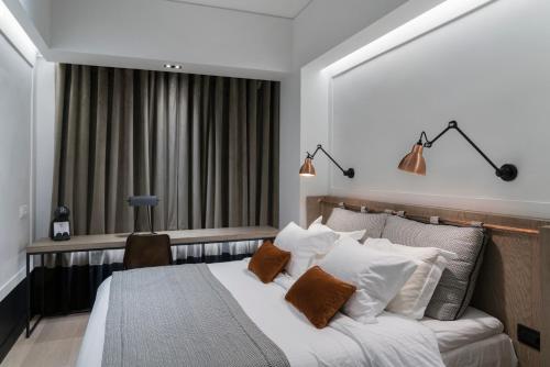 a bedroom with a white bedspread and a white comforter at Niki Athens Hotel in Athens