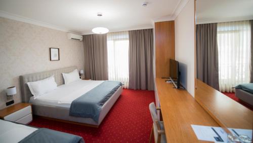 a hotel room with a bed and a television at Holiday Resort in Velika Slatina