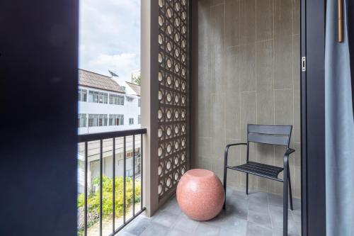 a balcony with a chair and a window at Reno hotel in Bangkok