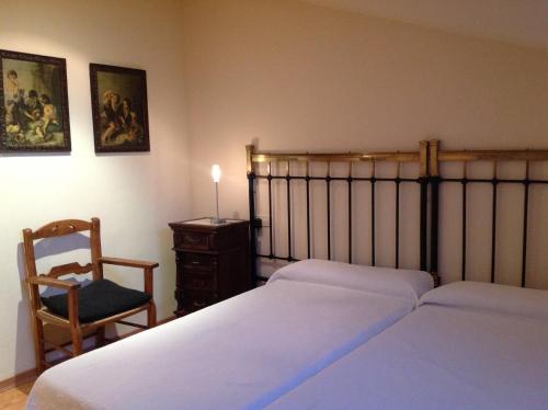 1 dormitorio con 2 camas, silla y escritorio en Galican Casa Rural en Moriscos