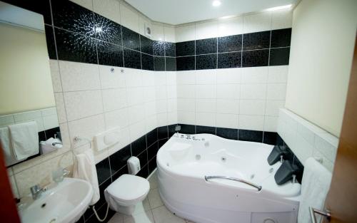 Łazienka z białą toaletą i umywalką w obiekcie Holiday Resort w mieście Velika Slatina