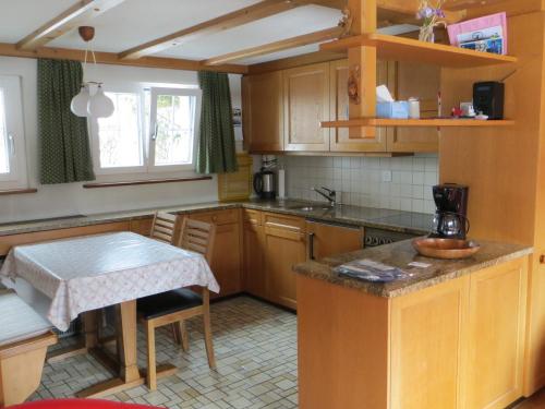 a kitchen with wooden cabinets and a table in it at Chalet Petite Fleur in Adelboden