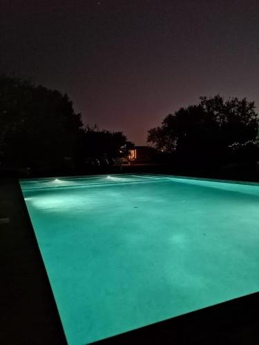 a large pool of green water at night at The Farm Tiny House - Tiny Casa in Chiclana de la Frontera