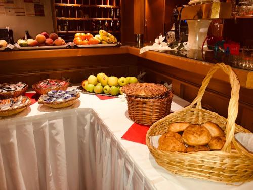 a table topped with baskets of bread and fruit at Louis Hotels in Schmitten