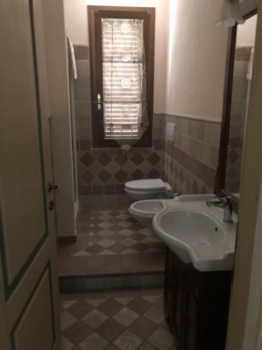a bathroom with two sinks and a toilet at Casa in campagna a due passi dal mare in Pisa