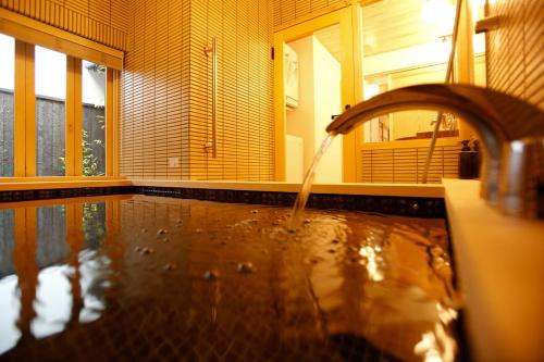 a bathroom with a tub with a water fountain at Yamagata Kyomachi Hatago Gojo Nishinotoin in Kyoto