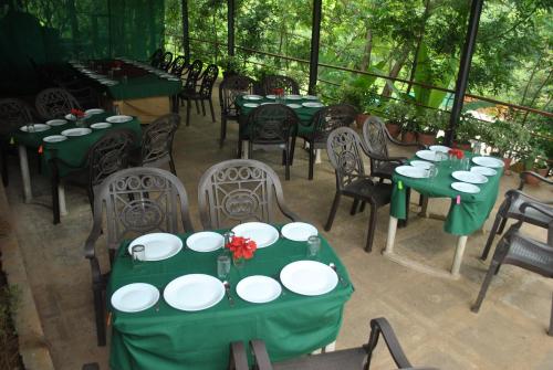 a group of tables and chairs with green table cloth at Wild Camp- The Nature Resort in Khodāla