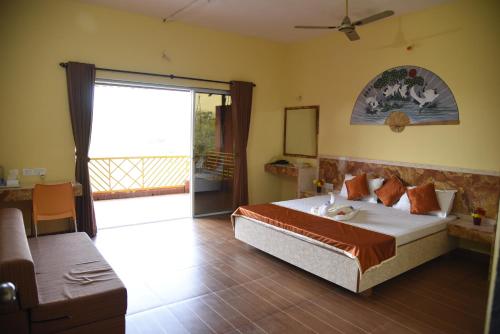a bedroom with a bed and a large window at Wild Camp- The Nature Resort in Khodāla