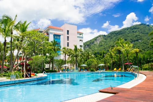 ein Pool in einem Resort mit Bergen im Hintergrund in der Unterkunft HOTEL CHAM CHAM - Tainan in Nanxi