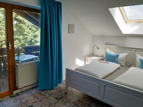 una camera da letto con un letto con tende blu e una finestra di Appartements Apfelblüte a Bad Feilnbach