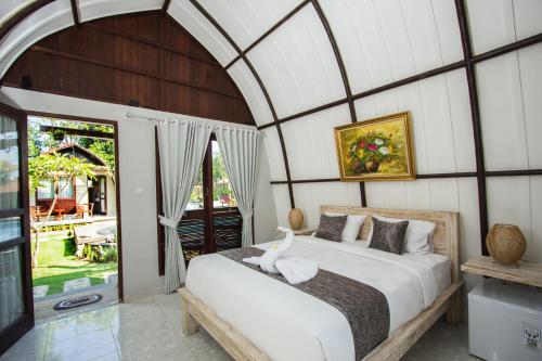 a bedroom with a bed in a room with a window at Papa Sun Villas in Nusa Penida