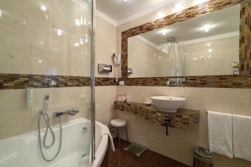 a bathroom with a tub and a sink and a mirror at Hotel Bel Sito e Berlino in Venice