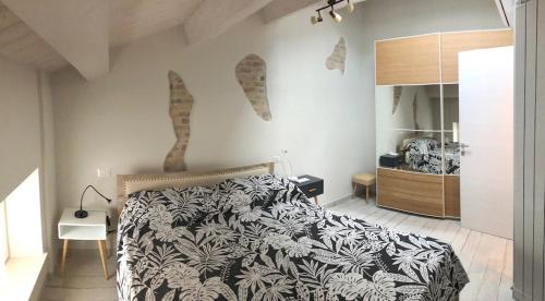 ein Schlafzimmer mit einem Bett mit einer schwarzen und weißen Decke in der Unterkunft B&B LOFT EDEL BEACH in Civitanova Marche