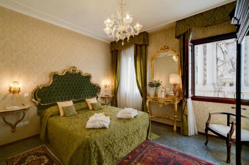 ヴェネツィアにあるHotel Bel Sito e Berlinoのベッドルーム1室(緑色のベッド1台、タオル付)