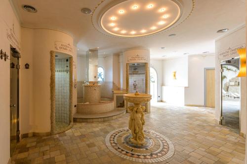 un baño con una estatua en el medio de una habitación en Hotel Christoph en Valdaora