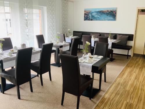 un comedor con mesas, sillas y una pintura en Designhotel Im Südfeld en Kamen