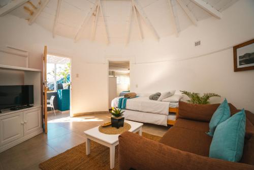 een woonkamer met een bed en een bank bij Surf Motel in Umdloti