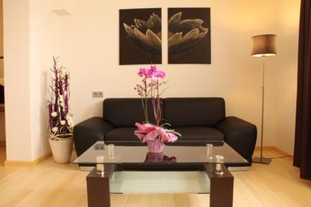 a living room with a couch and a table with flowers at Designhotel Im Südfeld in Kamen