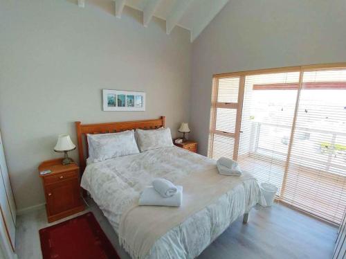 a bedroom with a large bed with two towels on it at Crystal Sea House in St Helena Bay