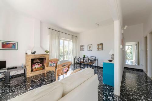 a living room with a white couch and a fireplace at JOIVY Sea View Flat with Balcony, Cinque Terre in Monterosso al Mare