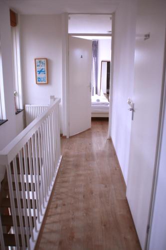a hallway with a staircase and a room with a bed at Floriande Stay in Hoofddorp