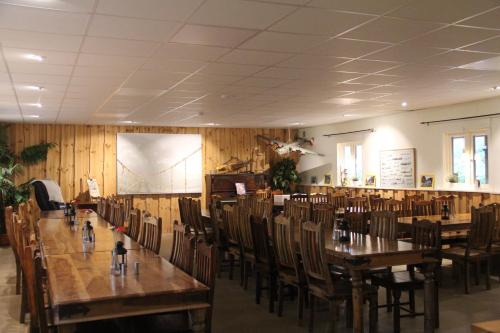 comedor con mesas y sillas de madera en Äventyrscampen, en Sjöbo