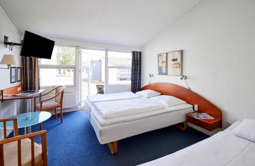 a hotel room with a bed, chair, and table at Zleep Hotel Kolding in Kolding
