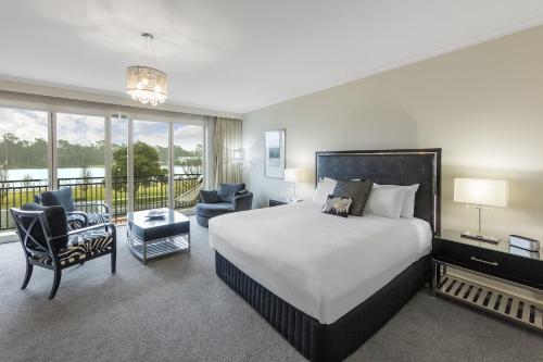 a hotel room with a bed and a balcony at The Carrington Hotel in Shepparton