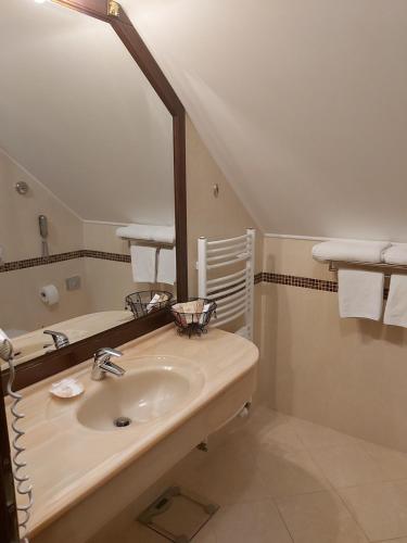 a bathroom with a sink and a large mirror at Aqua Marina in Karlovy Vary