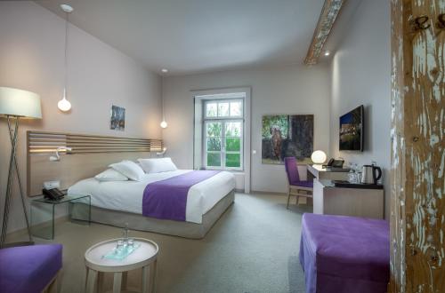 a bedroom with a king sized bed and a desk at Hydrama Grand Hotel in Drama