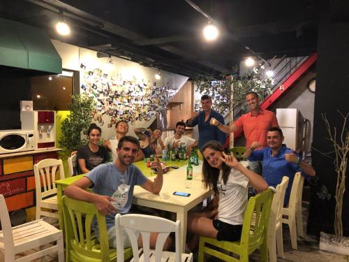 a group of people sitting around a table with drinks at Doobaki Hostel in Gyeongju
