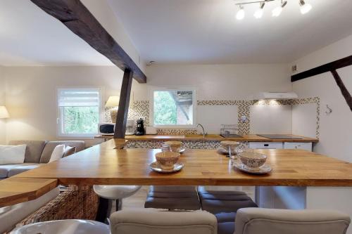 a kitchen with a large wooden table and chairs at Appartement Ecuries du Val de Mai, 10pers in Talmas