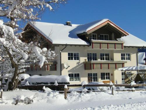 uma casa coberta de neve com árvores cobertas de neve em Haus Bergkristall em Bad Hindelang