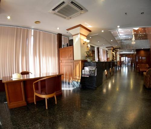 a large room with a lobby with a bar and chairs at Kawan Hotel in Sibu