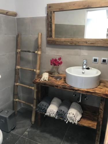 a bathroom with a sink and a shelf with towels at El Lagar de los Abuelos in Arcos de la Frontera