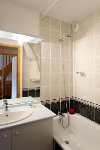 une salle de bain avec un lavabo, une baignoire et une douche dans l'établissement travelski home select - Résidence Les Hauts de Valmeinier, à Valmeinier