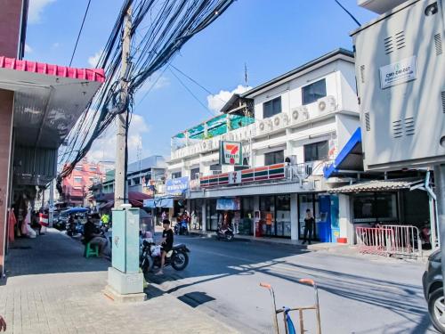 a busy city street with buildings and a crane at HOMEY-Sleepy Don Mueang Airport Hostel in Bangkok