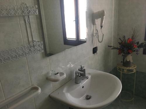 Baño blanco con lavabo y espejo en ca vittoria, en Busco